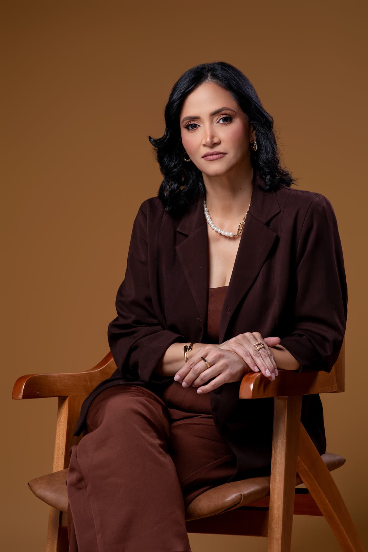Juêzessy Brandão sentada, em retrato profissional